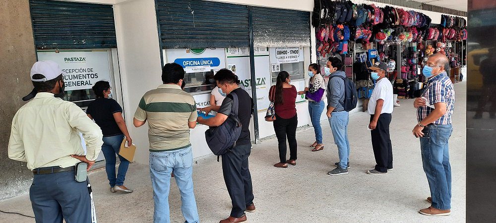 Persona entregando documentos en ventanilla municipal