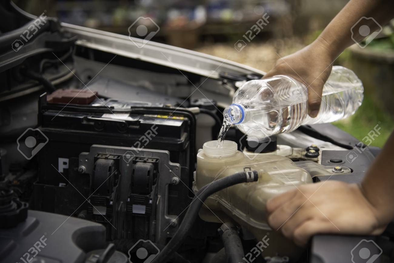 Radiador de coche siendo llenado con agua