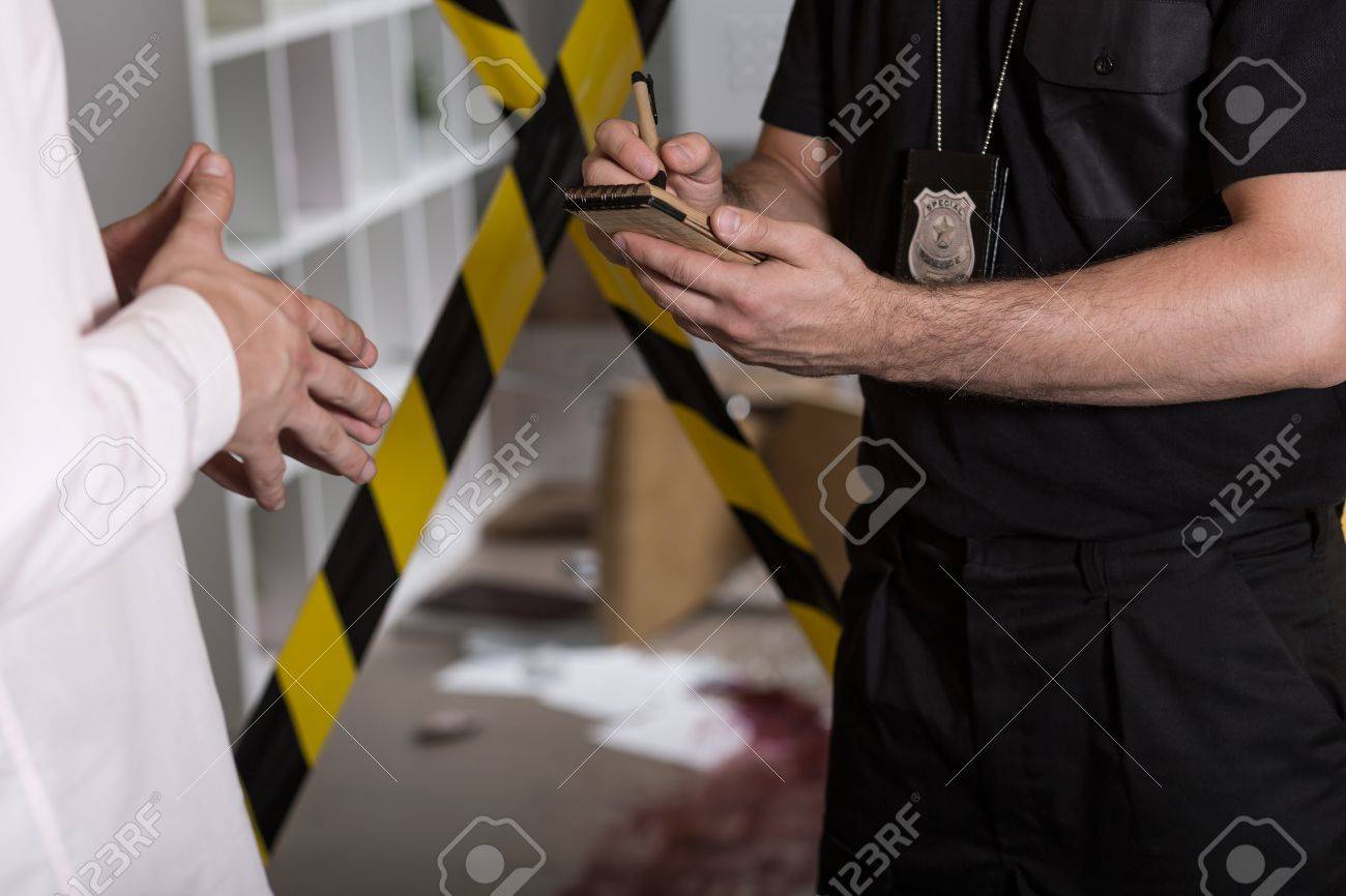 Fotografía de un policía tomando declaración