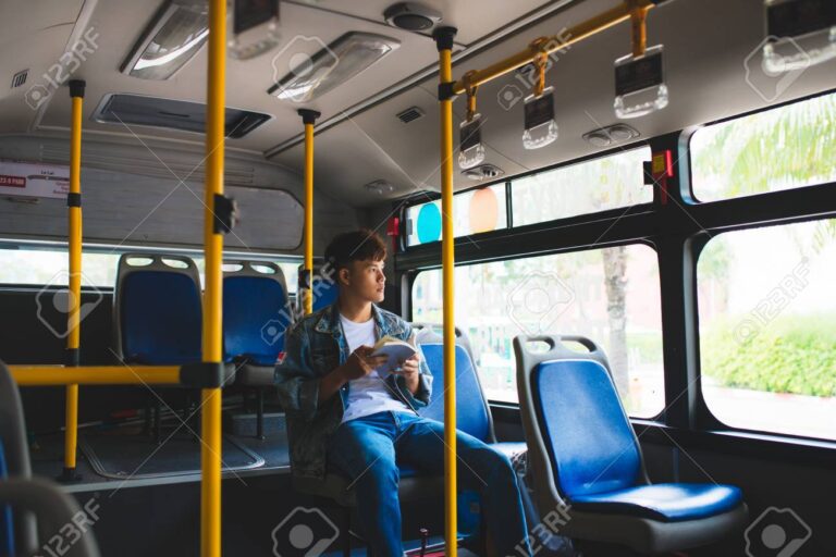 84280208 joven sentado en autobus de la ciudad y leyendo un libro