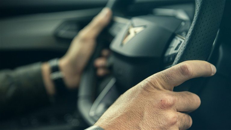 Manos sujetando volante con precaución al acelerar