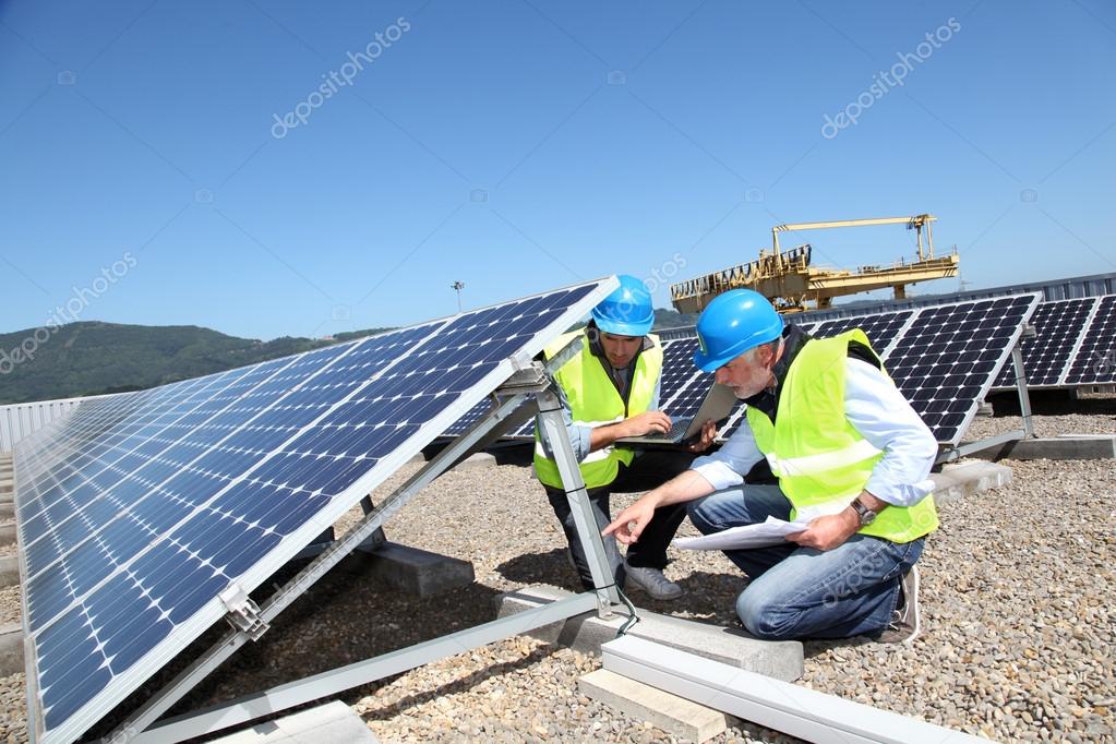 Electricista revisando paneles solares en tejado