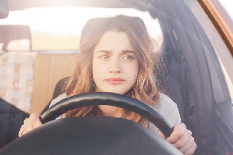 el conductor femenino nervioso se sienta en la rueda ha preocupado expresion como los afraids para conducir coche sola por 115923672