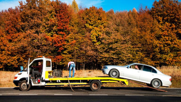 gruista remolcando un vehiculo en su grua en la carretera 2