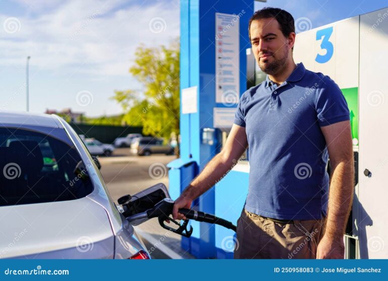 hombre adulto llenando el tanque de gasolina un auto en la gasolinera 250958083