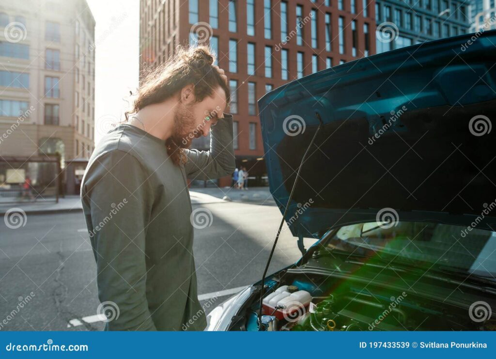 hombre mirando confundido a su coche