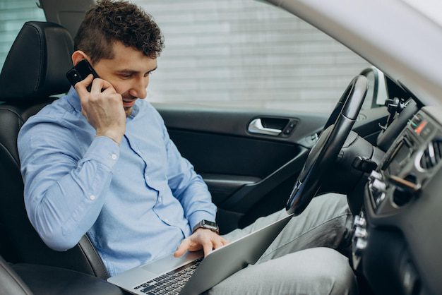 Persona trabajando en su laptop en coche