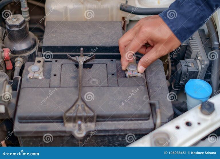 mano que comprueba y repara la bateria de coche 106938451