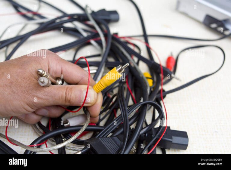 manos sujetando cables de automovil desordenados