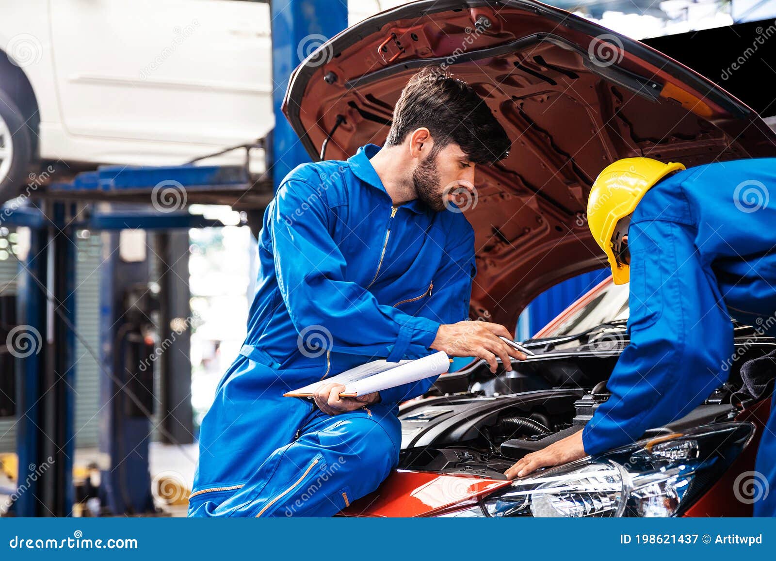 Manos de mecánico revisando dirección del coche