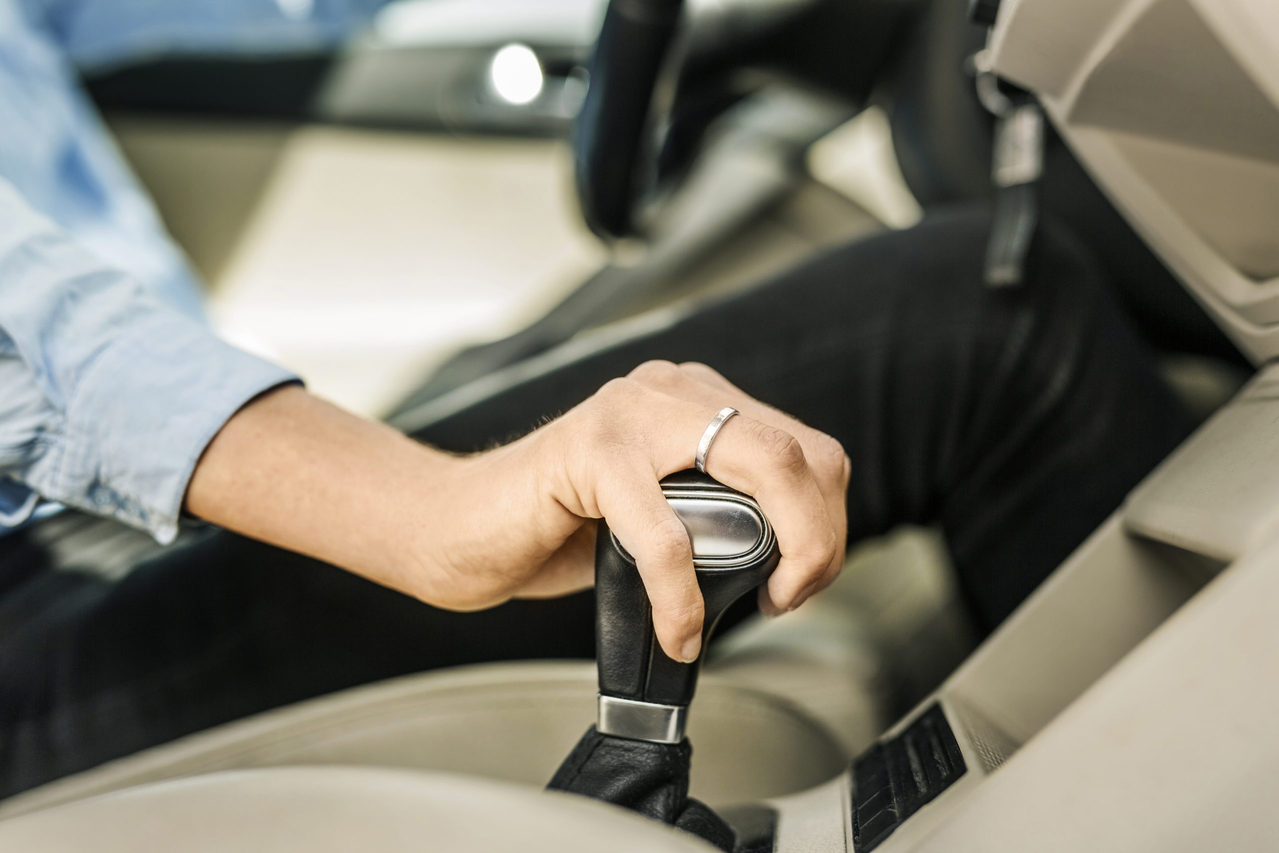 Persona intentando cambiar a primera velocidad coche