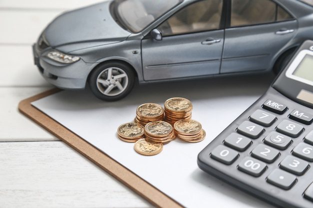 Coche en venta con calculadora y dinero