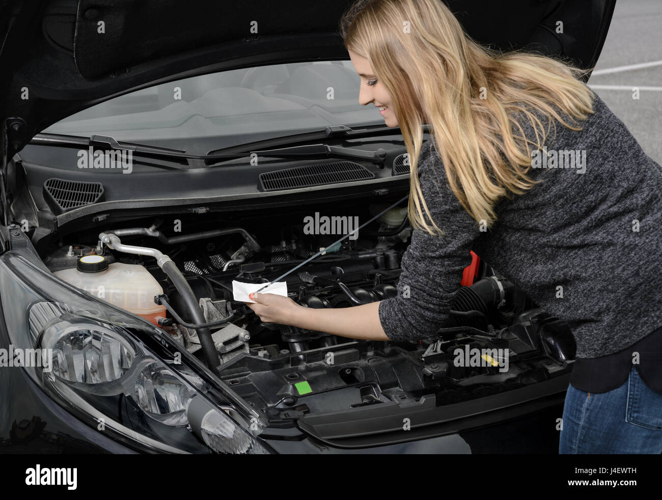Qué pasa cuando un carro va en marcha y se apaga 3 Conductora revisando el nivel de aceite
