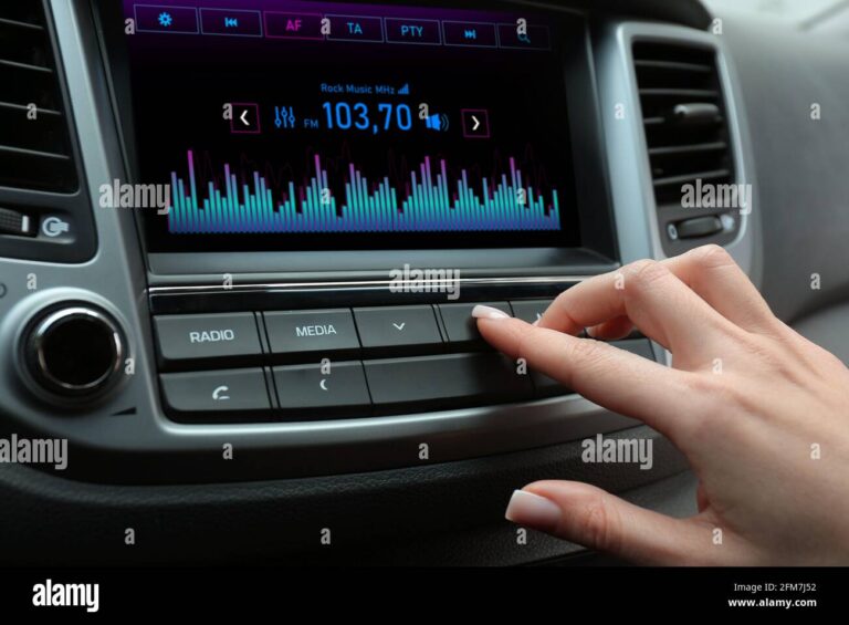 mujer sintonizando una emisora de radio en el coche 2fm7j52