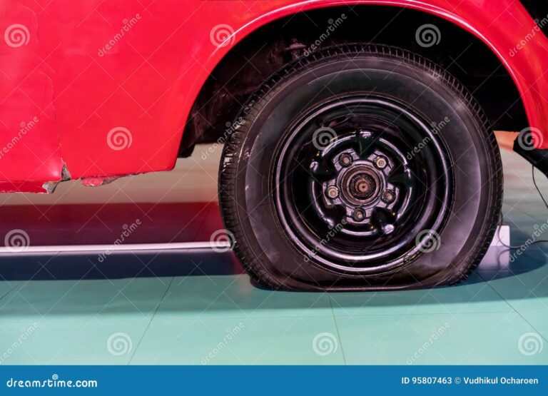 neumatico desinflado danado de un coche rojo viejo 95807463