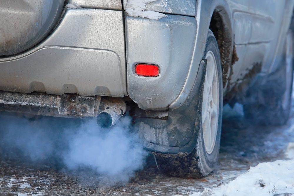 Coche con humo saliendo del escape al acelerar