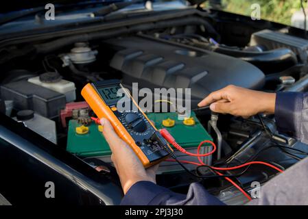 Manos probando batería de un automóvil