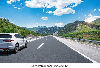 Coche recorriendo carretera con paisaje natural