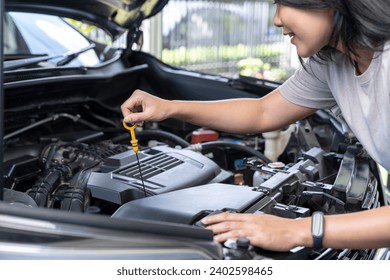 Manos revisando motor de un coche