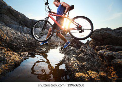 young athlete crossing rocky terrain 260nw 139602608
